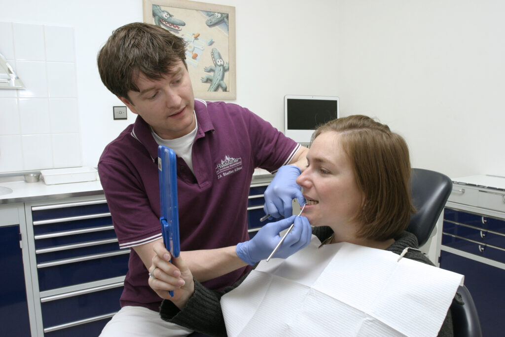Eine Patientin schaut nach der Lasertherapie in den Spiegel.